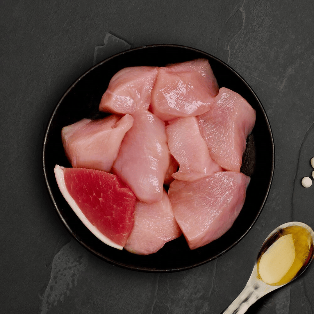 The Fresh ingredients of the Canagan Chicken with Ham Cat Food Tin 75g displayed on a plate.