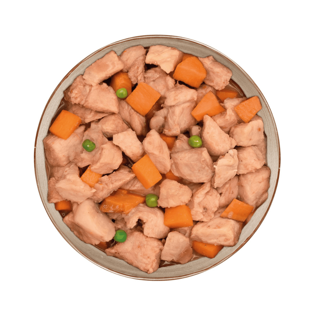 Pet food bowl with pork, carrots, and peas on a white background