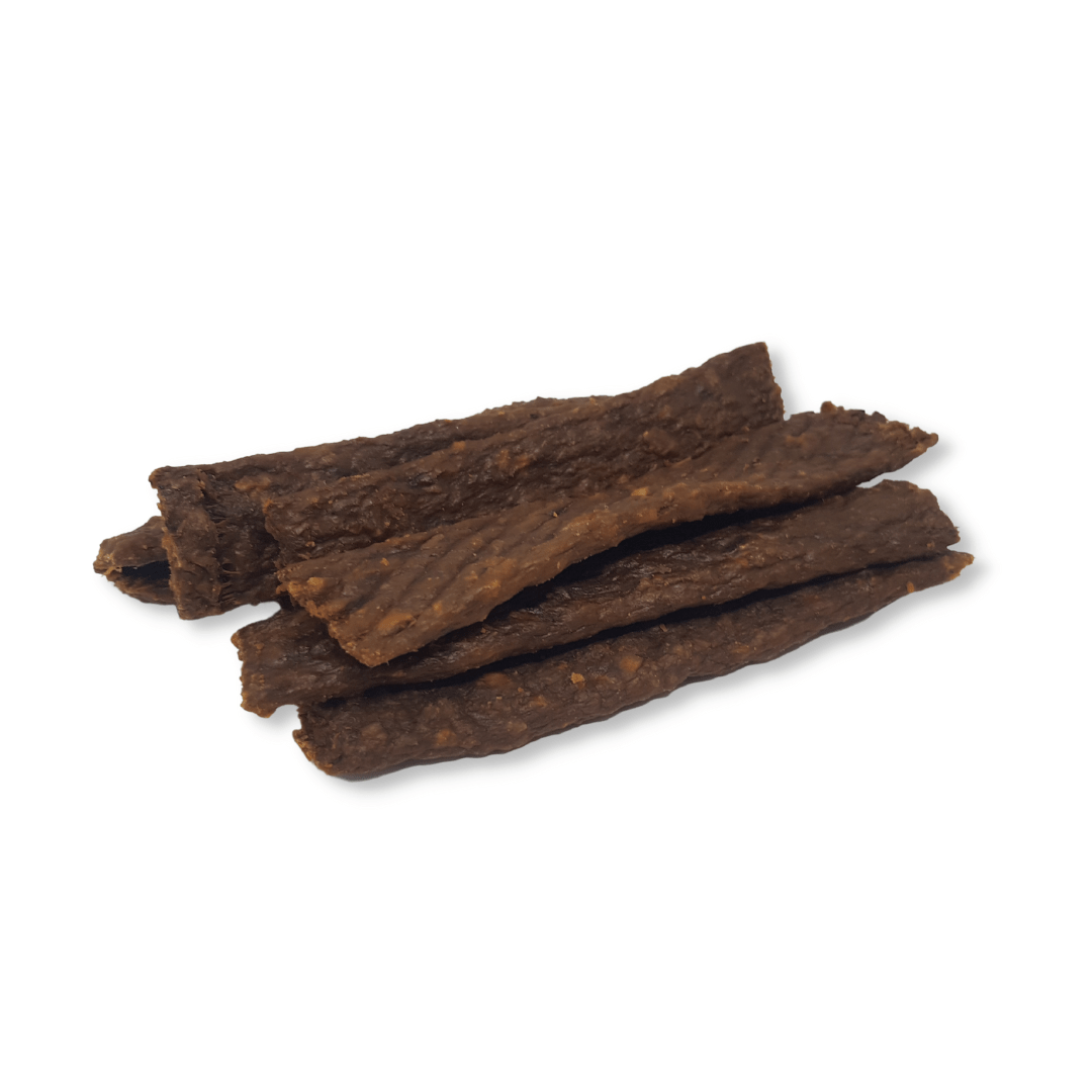 Dried pheasant strips stacked on a white background