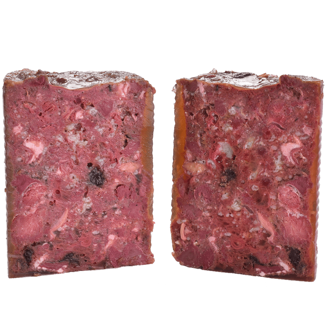 Carnilove Venison & Reindeer wet dog food removed from the tin and cut in half to show it's profile. You can see many different textures and ingredients including fruit