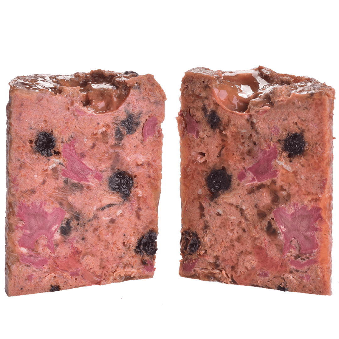 The Carnilove Lamb and Wild Boar wet dog food removed from the tin and cut in half to show it's profile. You can see many different textures and ingredients including fruit