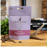 The innocent cat venison slice with potato treats displayed loose beside their packaging and a deer antler.