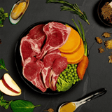 The fresh ingredients of the Canagan Shepherd's Pie Wet Dog Food 400g in a bowl. There are some functional additives like green lipped mussels placed around the bowl on the counter.