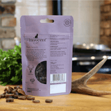 The innocent cat venison slice with potato treats displayed loose beside their packaging and a deer antler.