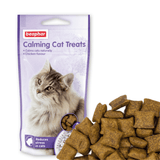 A bag of Beaphar Calming Cat Treats with a picture of a long-haired cat on the front, shown next to several brown kibble-style treats on a white background.