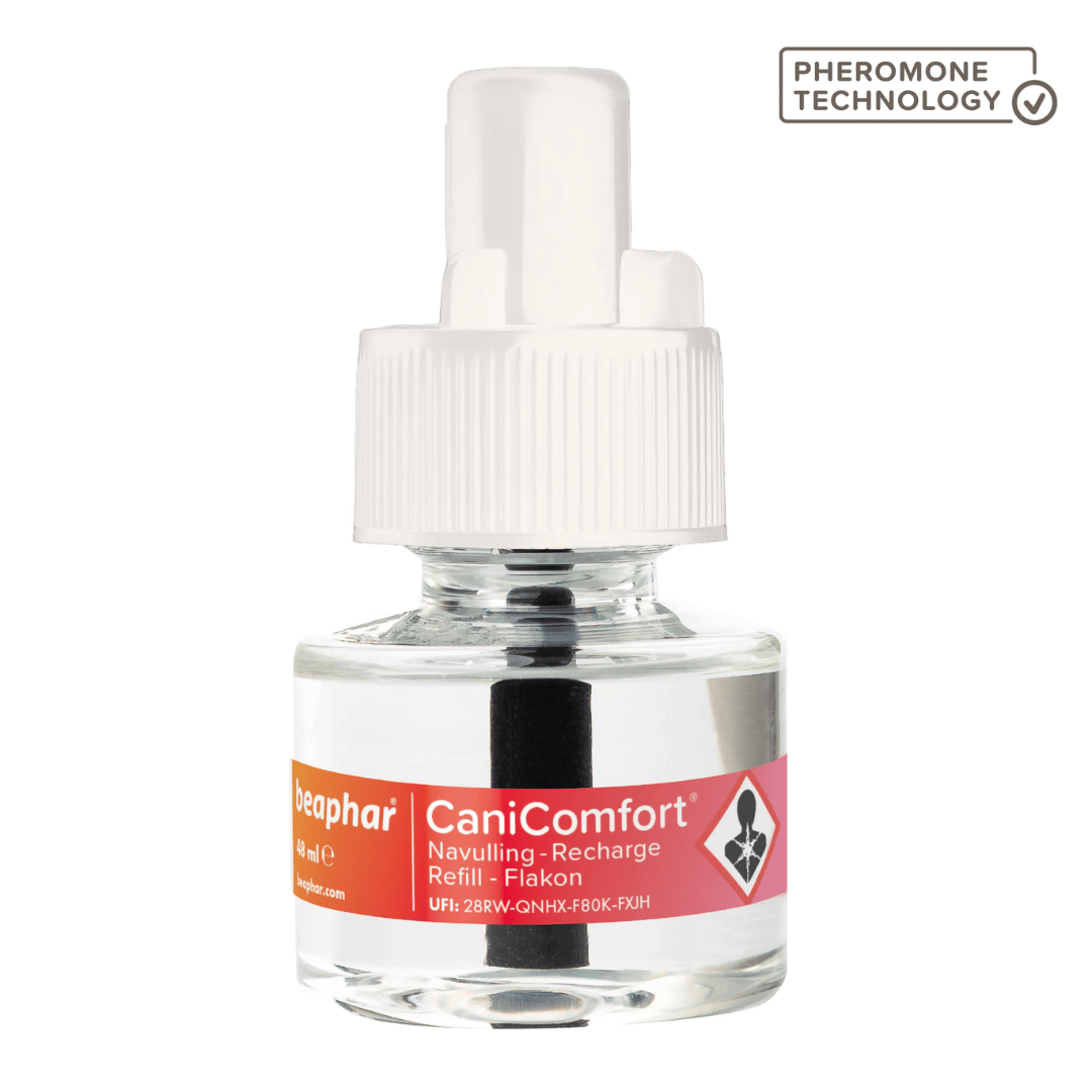 A clear glass refill bottle with a white plastic cap and a pink label reading CaniComfort, shown on a white background with a 'Pheromone Technology' badge in the top right.