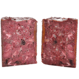 Carnilove Venison & Reindeer wet dog food removed from the tin and cut in half to show it's profile. You can see many different textures and ingredients including fruit
