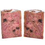 Carnilove Salmon and turkey wet dog food removed from the tin and cut in half to show it's profile. You can see many different textures and ingredients including fruit