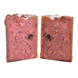 The Carnilove duck& pheasant wet dog food removed from the tin and cut in half to show it's profile. You can see many different textures and ingredients including fruit