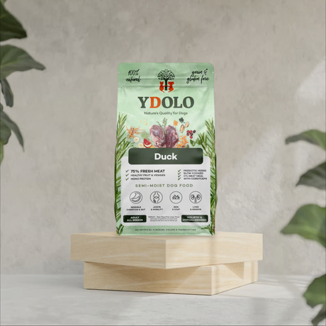 A bag of Ydolo duck semi moist cold pressed dog food on a wooden platform.